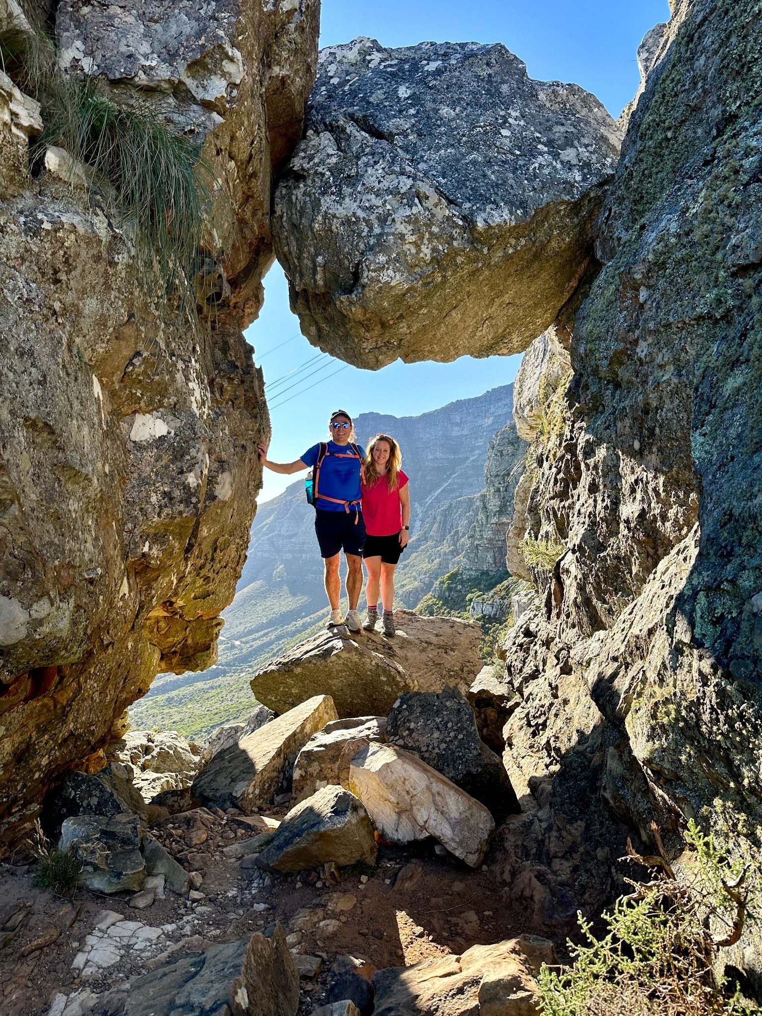 Hikers beneath a dramatic rock formation on the India Venster route on Table Mountain