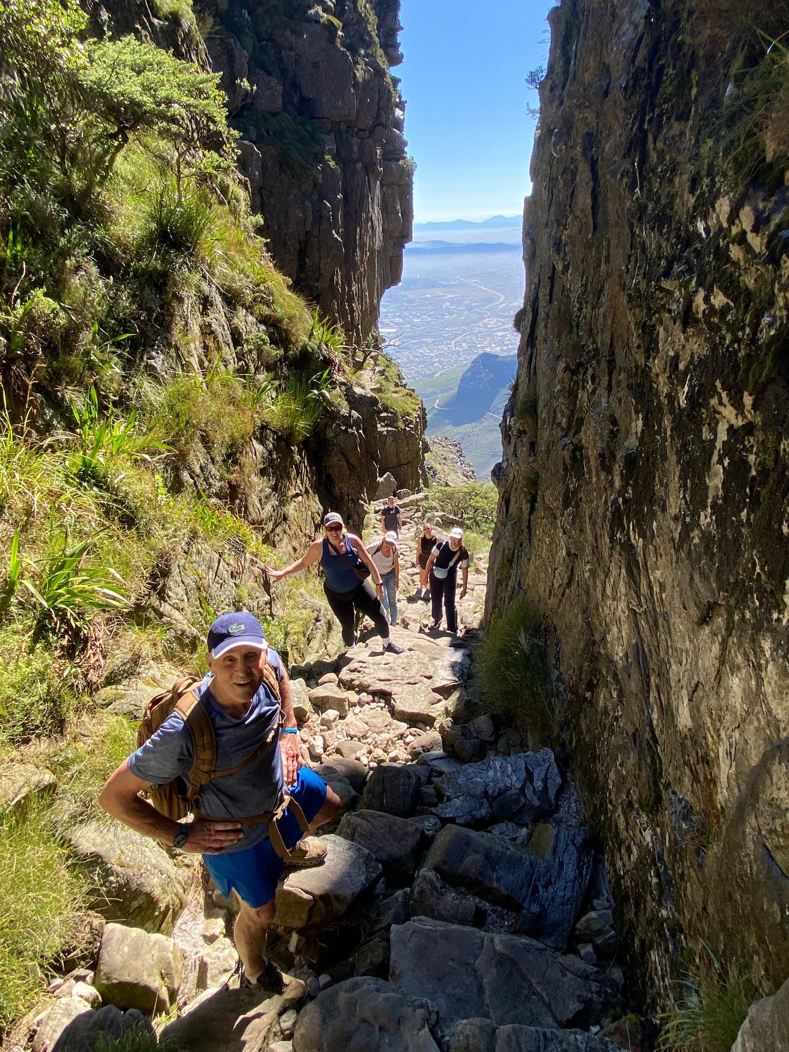 Hikers climbing through a steep rocky gorge on Table Mountain